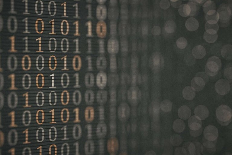 Codice binario su sfondo grigio acciaio e arancione che rappresenta i casi d’uso blockchain nei processi digitali.