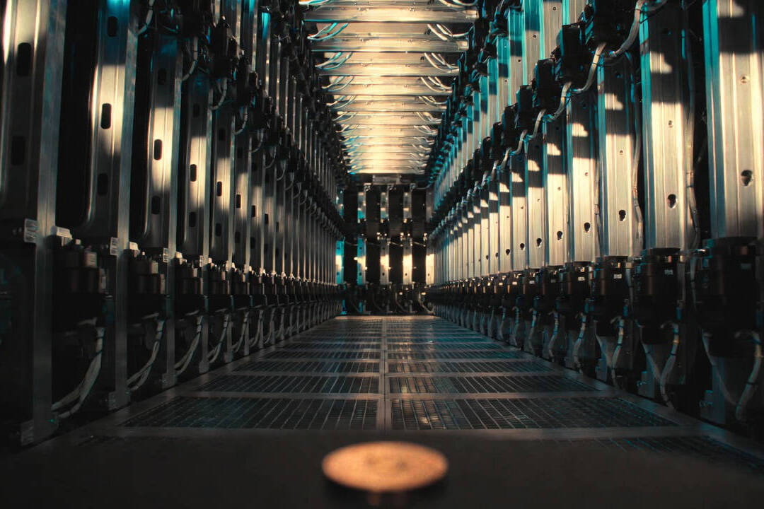 Economia delle macchine: corridoio di server rack con moneta fisica sul pavimento.