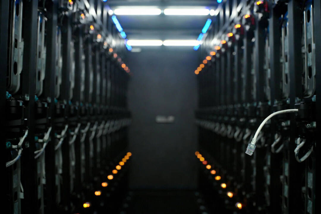 Resilienza operativa DORA: cavo ethernet scollegato in un corridoio di server rack con luci ambra intermittenti in una sala CED istituzionale.