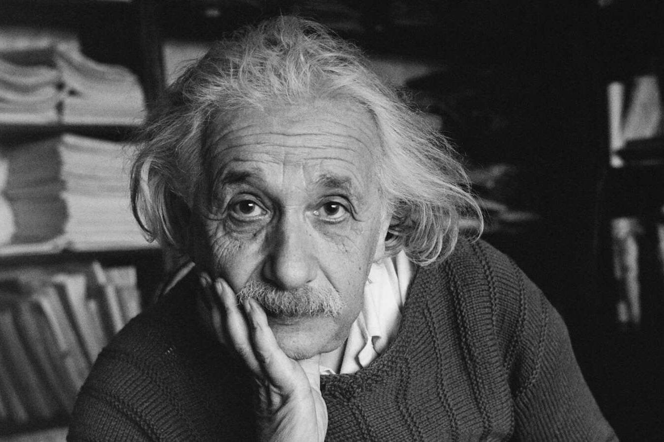 Il Dio di Spinoza: biblioteca vuota con scaffali geometrici e un libro aperto sotto una luce calda